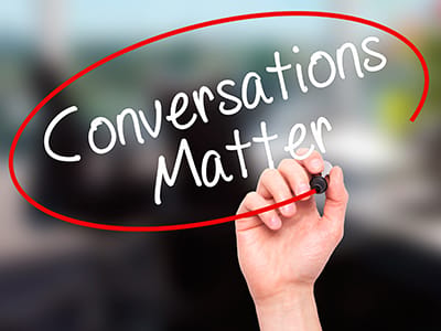 Man Hand writing Conversations Matter with black marker on visual board