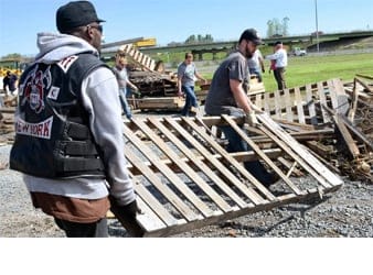 two gentlemen carrying a huge wooden pallet