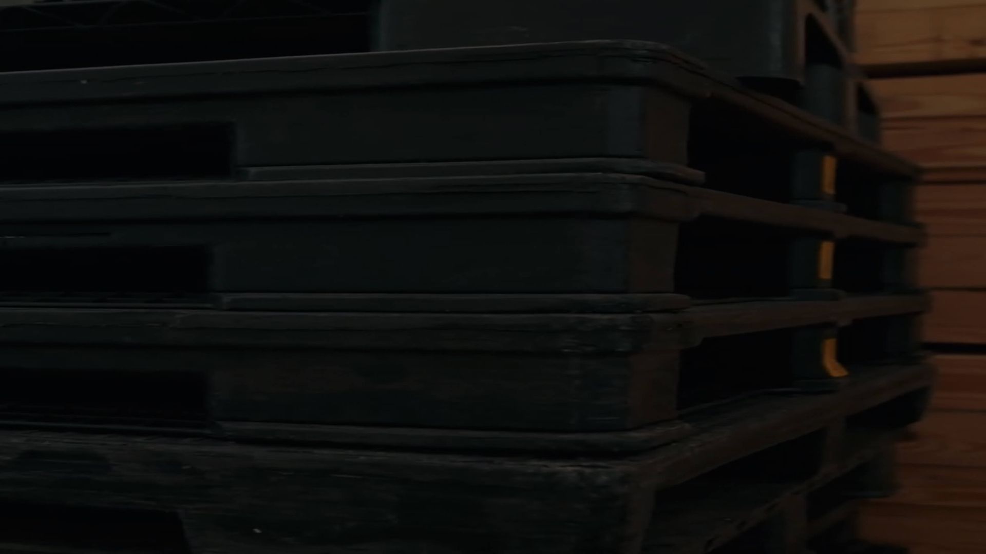 close-up of black plastic pallets with dark over lay