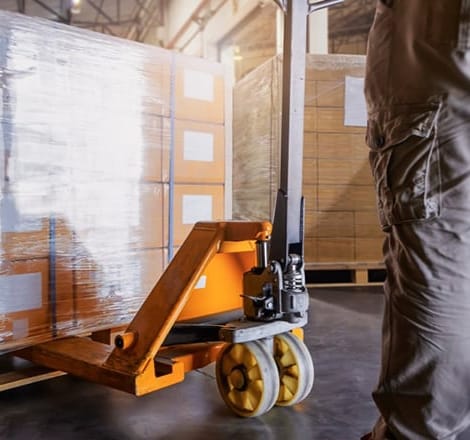 Close-up of gentleman moving pallets in warehouse