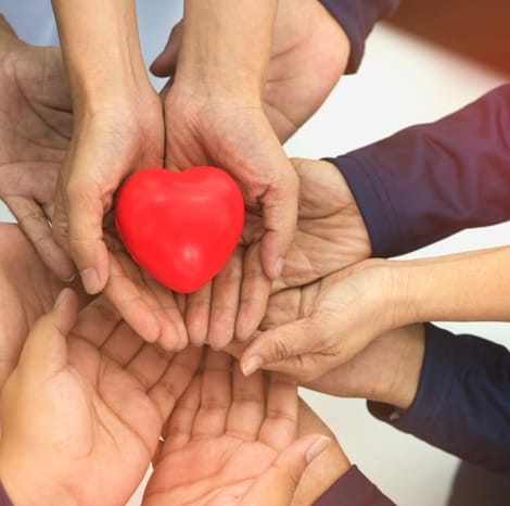 multiple hands holding a heart