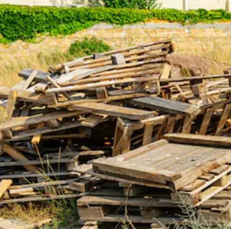 broken pallets and unwanted pallets stacked in a pile ready for trash