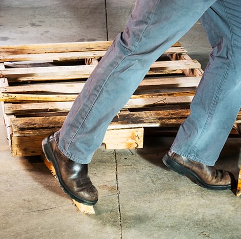 person tripping over a pallet inside a warehouse