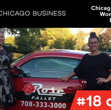 two woman smiling in front of their rose pallet vehicle
