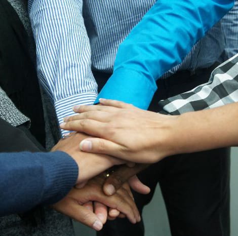 group of people with hands in the middle