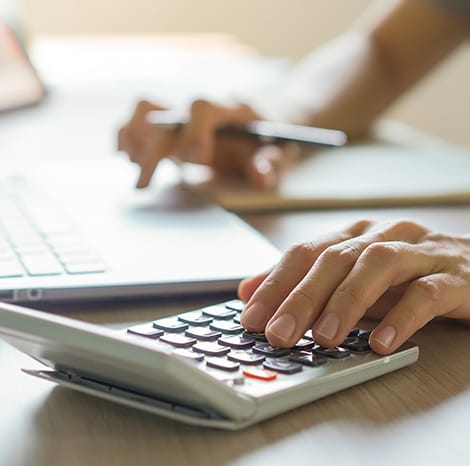 close-up of man typing on calculator