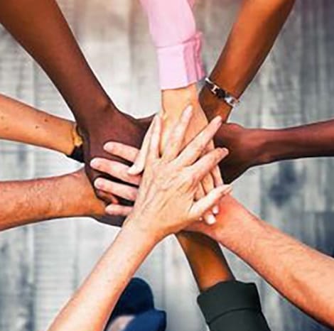 group of different people with their hands in the middle