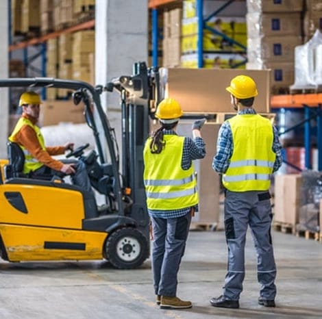 group of employess going over safety tips while handling pallets