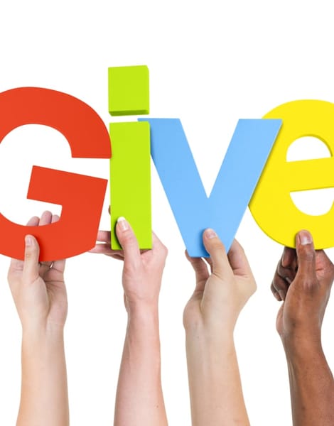 four people holding up "Give"