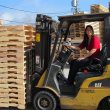 woman operating fork lift with pallets