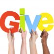 four people holding up "Give"