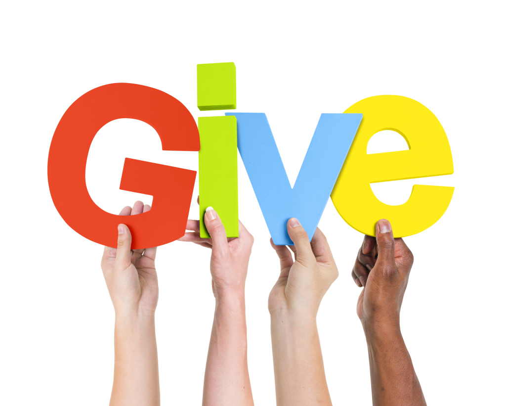 four people holding up "Give"