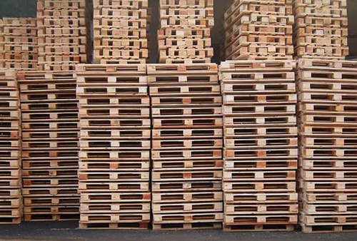 hundreds of wooden pallets stacked up