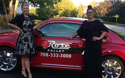 mia and amy posing in front of rose pallet company car