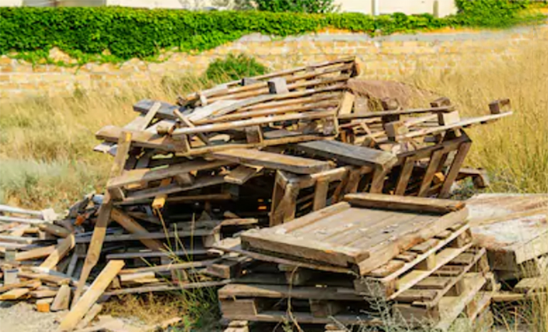 broken pallets and unwanted pallets stacked in a pile ready for trash
