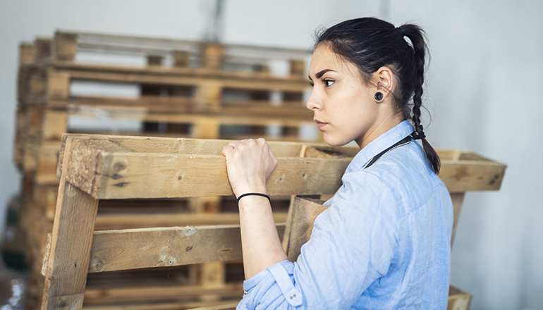 woman holding wooden pallet