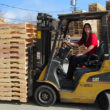 woman driving jack with pallets on it